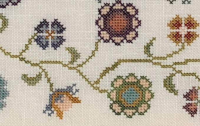 Close-up of cross-stitched floral pattern on fabric